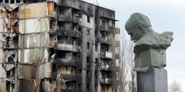 Ein Denkmal für den ukrainischen Dichter Taras Shevchenko und ein nationales Symbol erscheint mit Schussspuren vor dem Hintergrund eines Wohnhauses, das bei einem russischen Bombenangriff auf dem Zentralplatz in Borodinka, Ukraine, am Mittwoch, dem 6. April 2022, zerstört wurde. 