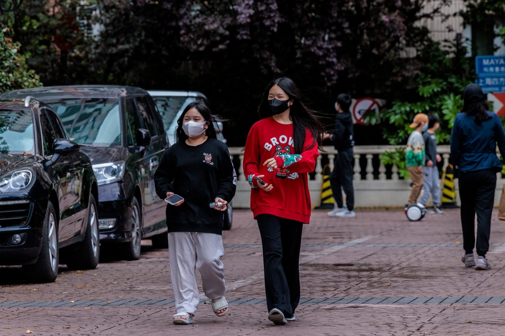Menschen gehen durch eine abgeriegelte Wohngemeinschaft in Shanghai, China, 23. April 2022.