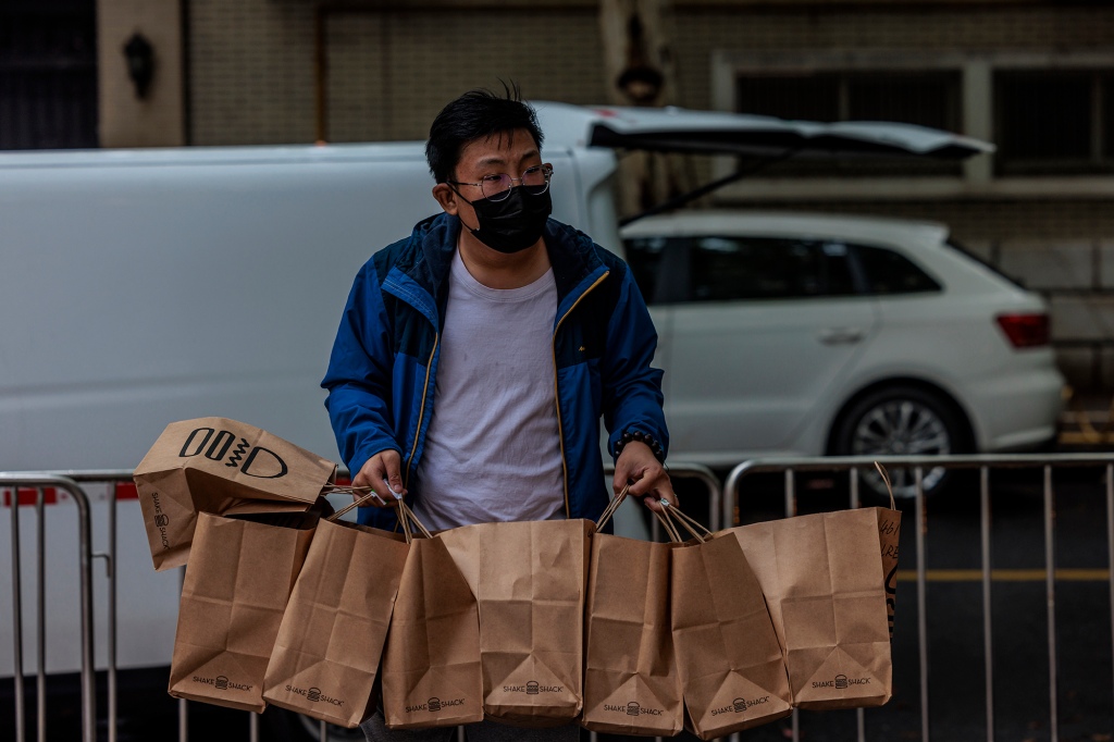 Ein Lieferarbeiter bringt Lebensmittel in eine geschlossene Wohngemeinschaft in Shanghai, China, 23. April 2022.