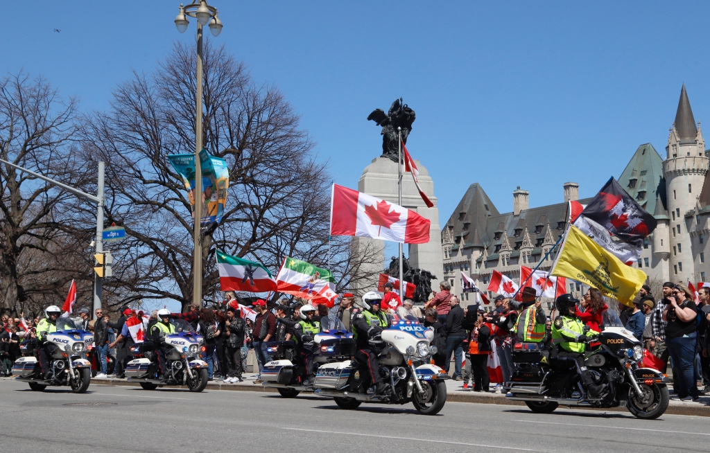 Polizisten auf Motorrädern passieren eine Demonstration, Teil einer Demonstrationsaufrufe im Konvoi-Stil "Donnergrollen" In Ottawa, Ontario, am Samstag, den 30. April 2022.