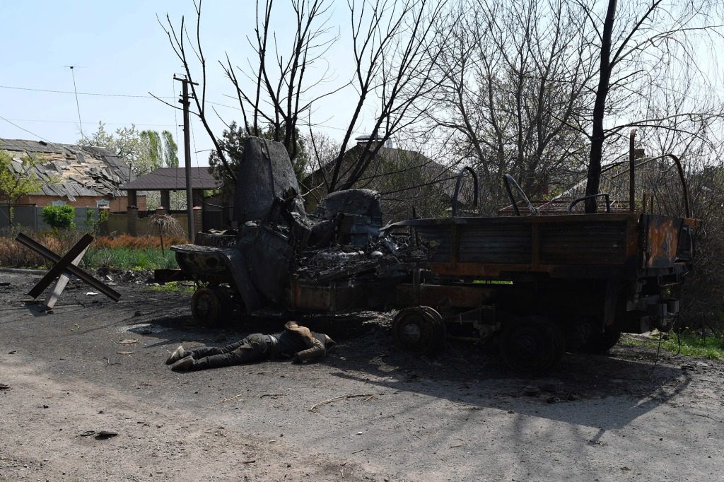 Die Leiche eines ermordeten russischen Soldaten liegt auf der Straße neben einem russischen Lastwagen im Dorf Velkhivka.