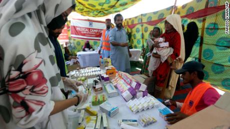Vertriebene Familien warten am 4. September 2022 an einer Verteilungsstelle in Sukkur, Pakistan, darauf, Medikamente zu erhalten.