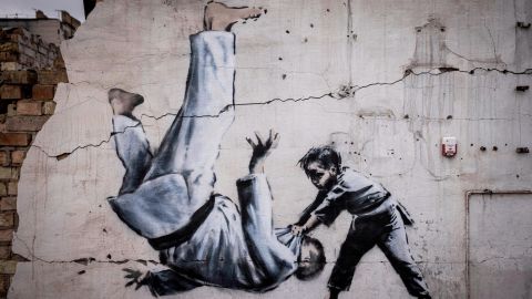 Ein Wandbild, das Banksy nicht offiziell beansprucht hat, zeigt einen Mann, der sich während eines Judo-Matches mit einem Jungen umdreht. 